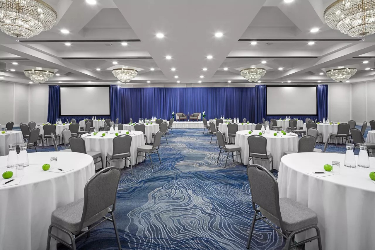 Chelsea Hotel ballroom set with round tables and stage