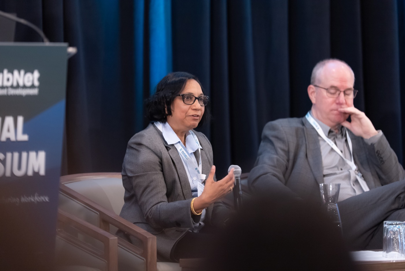 Two panelists listening during the symposium