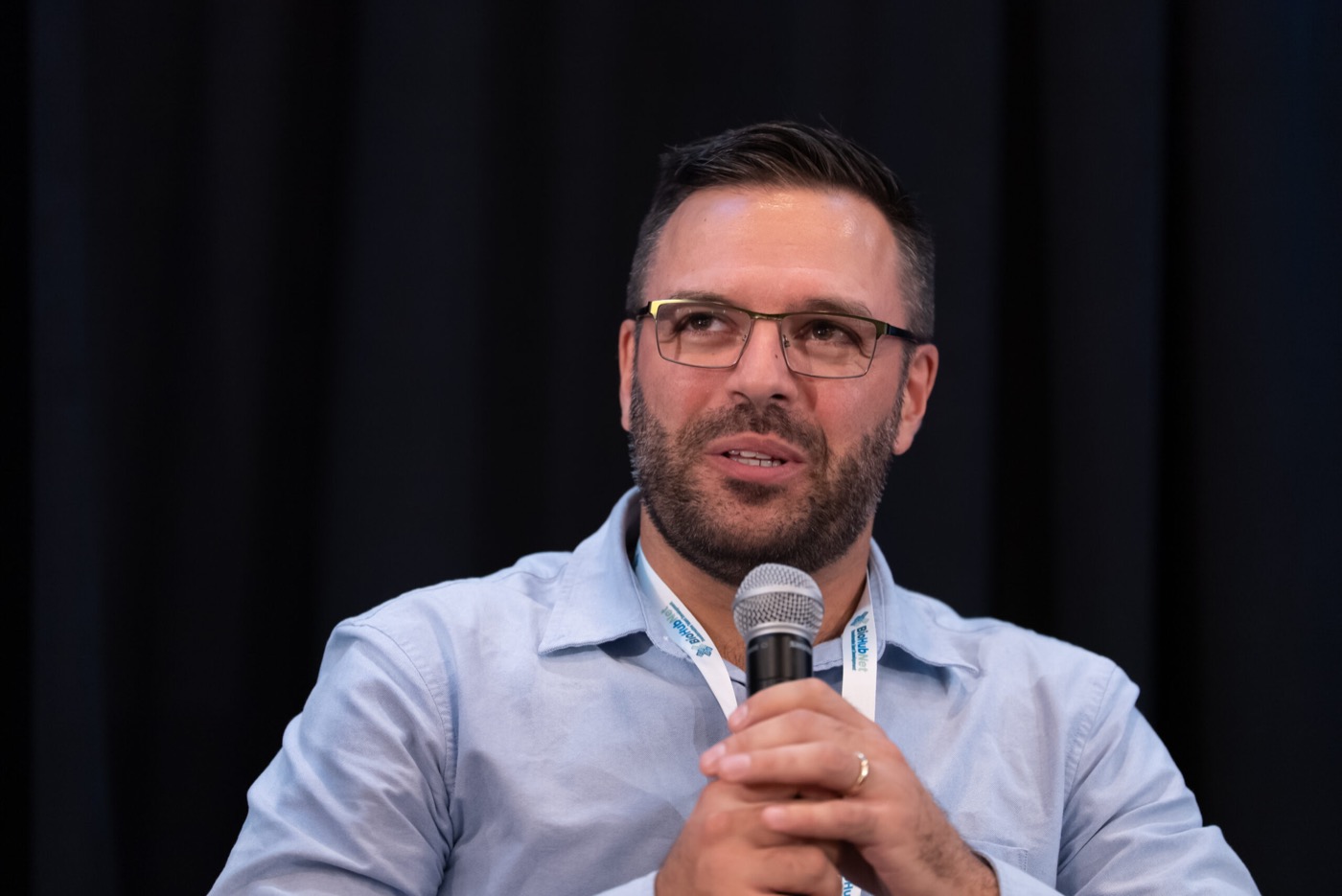 Panelist speaking while holding a microphone